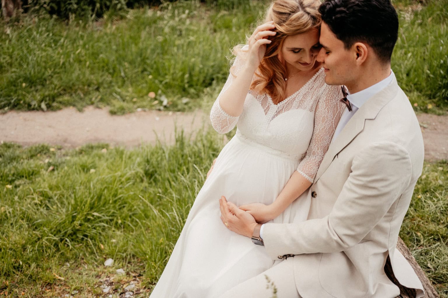 Hochzeitspaar im Grünen, verliebtes Paar in Brautkleid und Anzug, romantischer Moment im Freien.