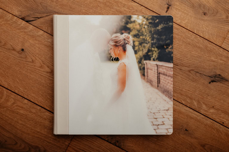 Hochzeitsfotobuch mit Braut und Bräutigam im Sonnenlicht.