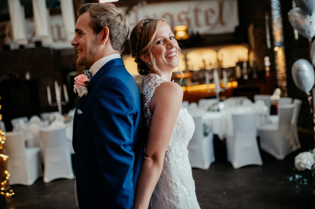 Hochzeitspaar im Tanzsaal, lachend und glücklich.