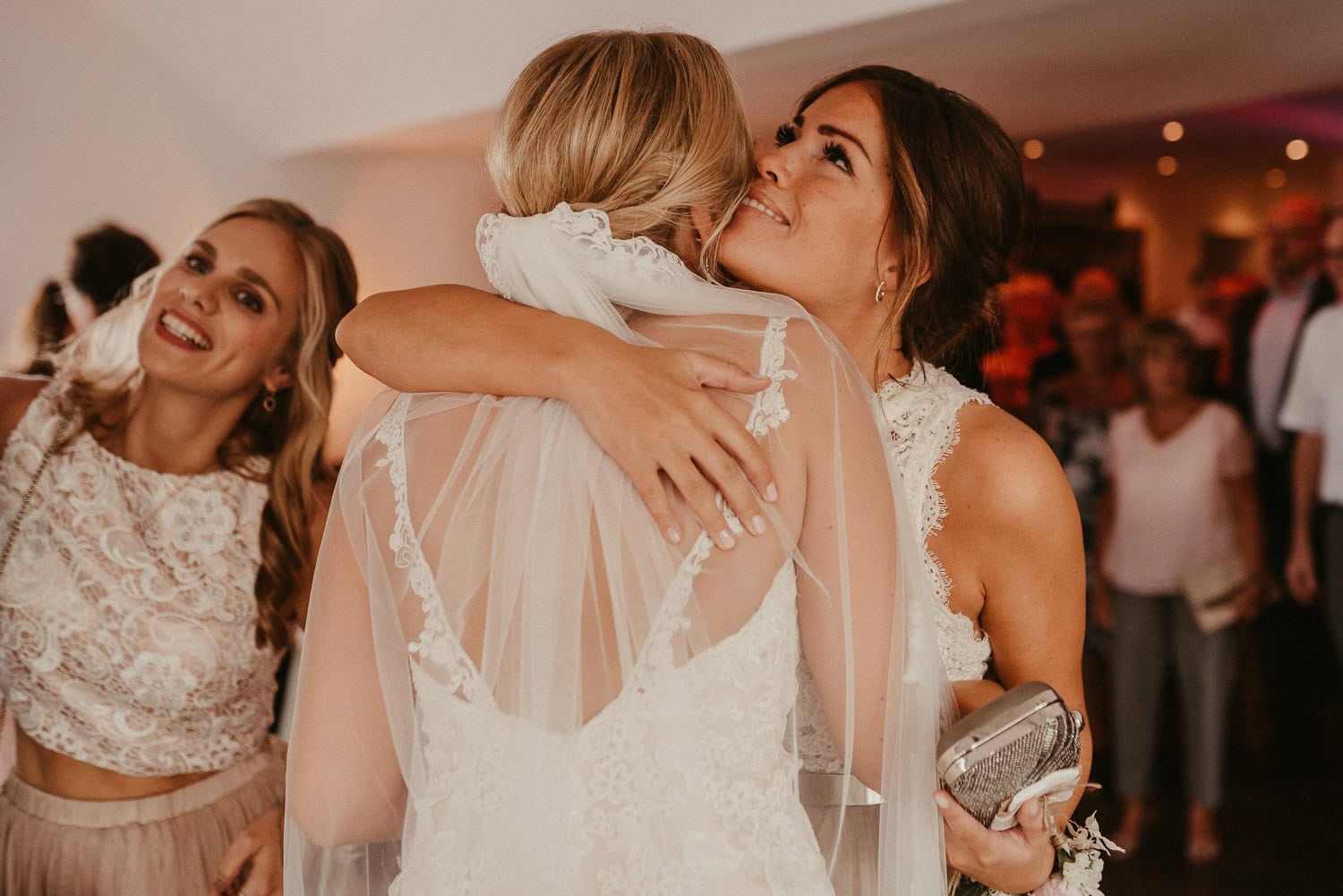 Zwei Frauen bei der Hochzeit in inniger Umarmung, Freude und Liebe im Mittelpunkt.