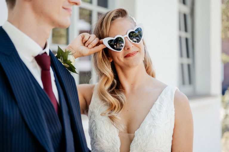Hochzeitspaar mit Herz-Sonnenbrille, glückliches Paar bei Hochzeit.