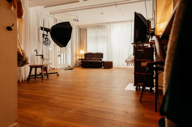 Innenraum eines Fotostudios mit professioneller Beleuchtung und Holzfußboden.