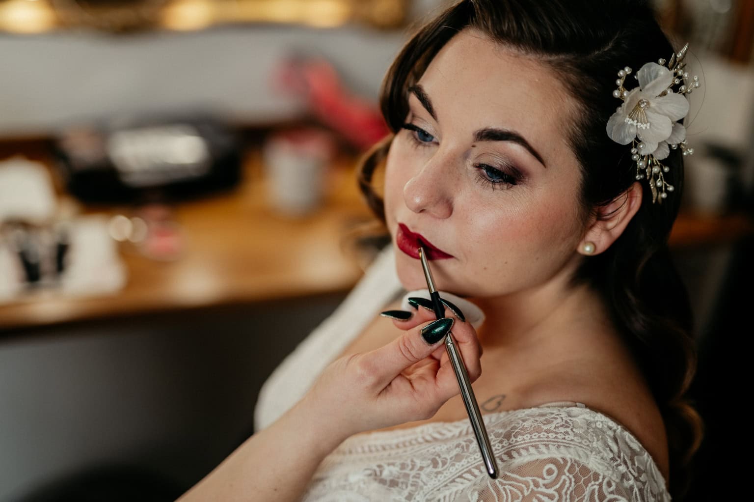 Braut erhält professionelles Make-up, während eine Make-up-Artistin Lippenstift aufträgt.