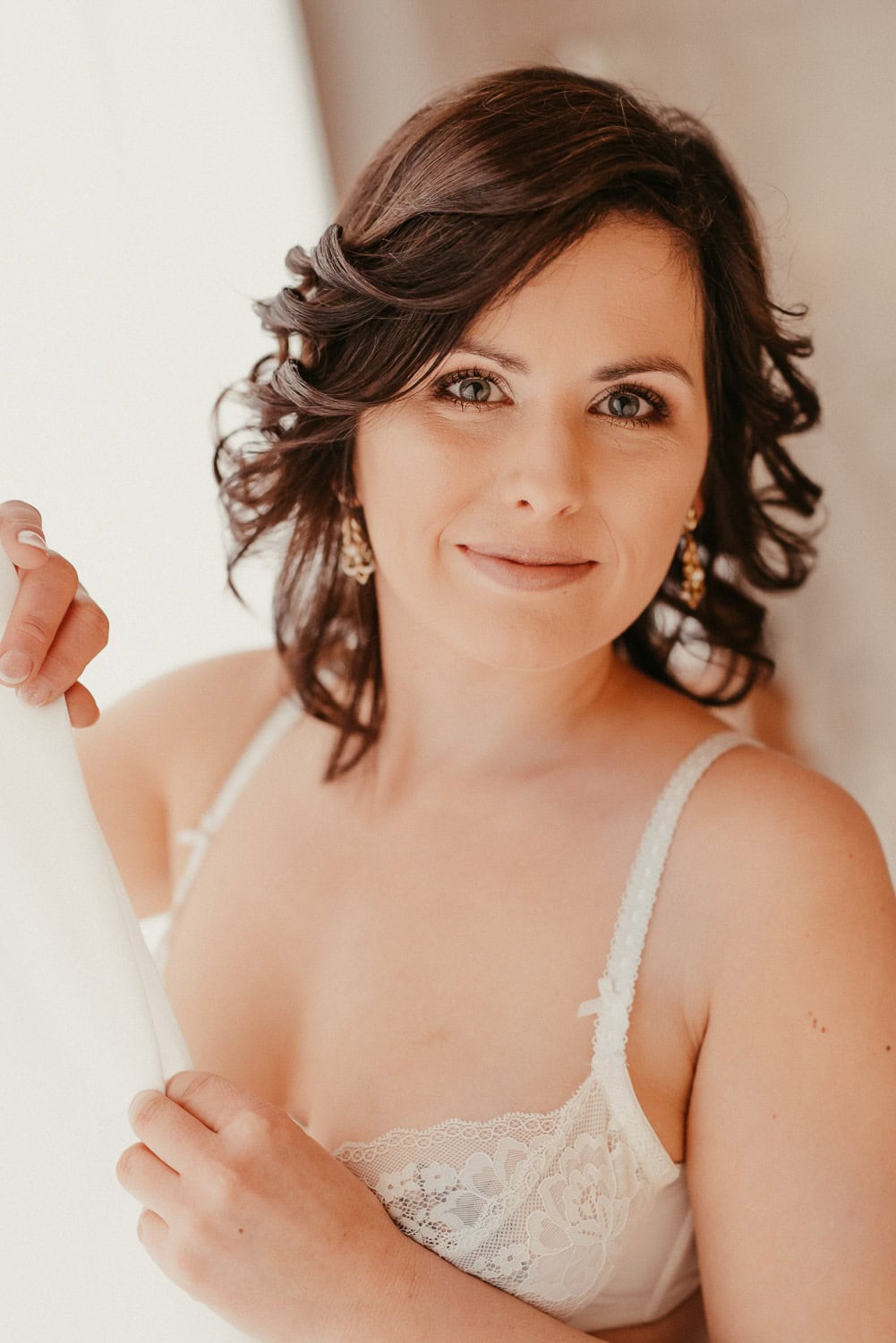 Frau in Brautkleid lächelt bei Hochzeitsfotografie.