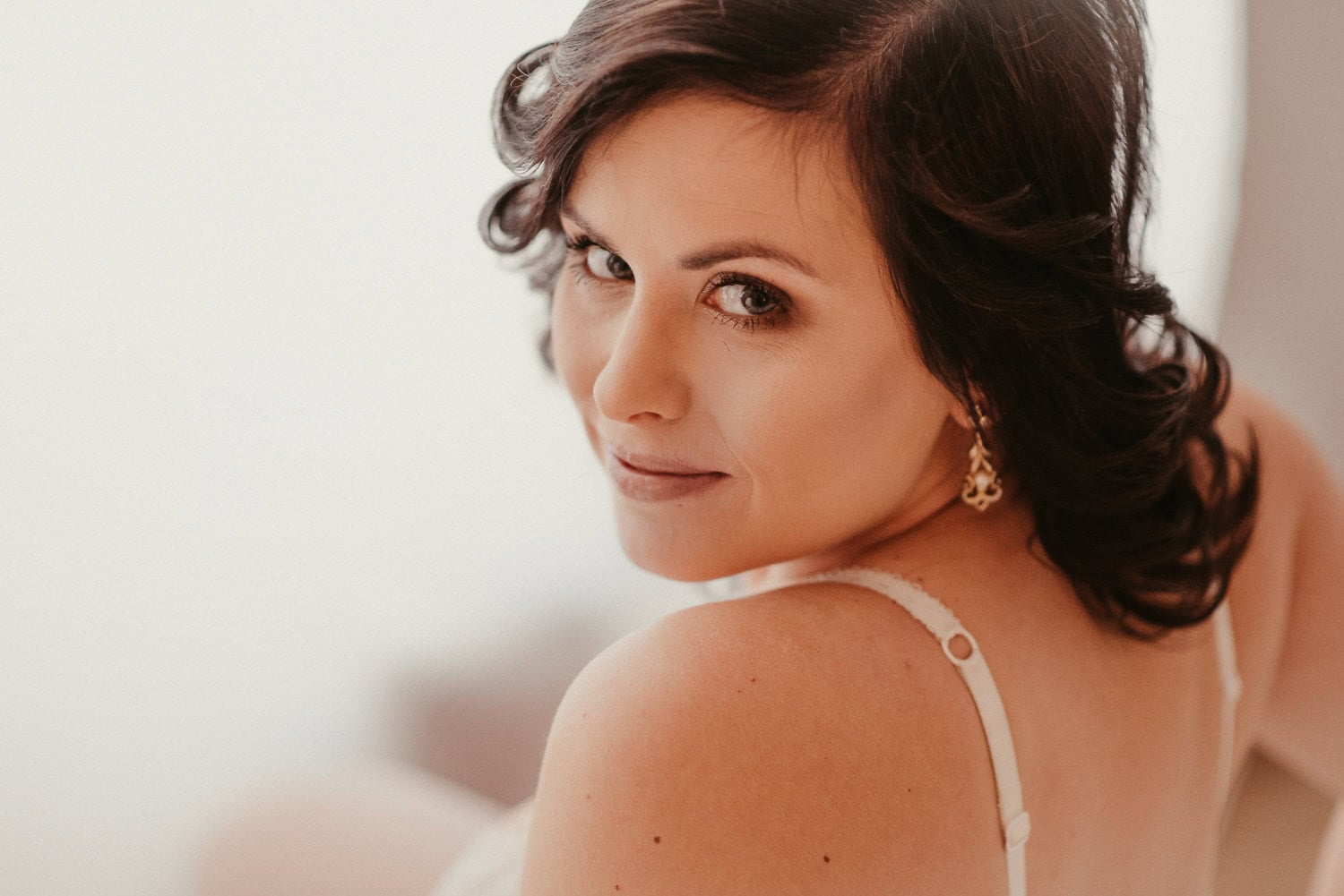 Braut mit braunen Haaren und freundlichem Blick, Nahaufnahme, Hochzeitskleid.
