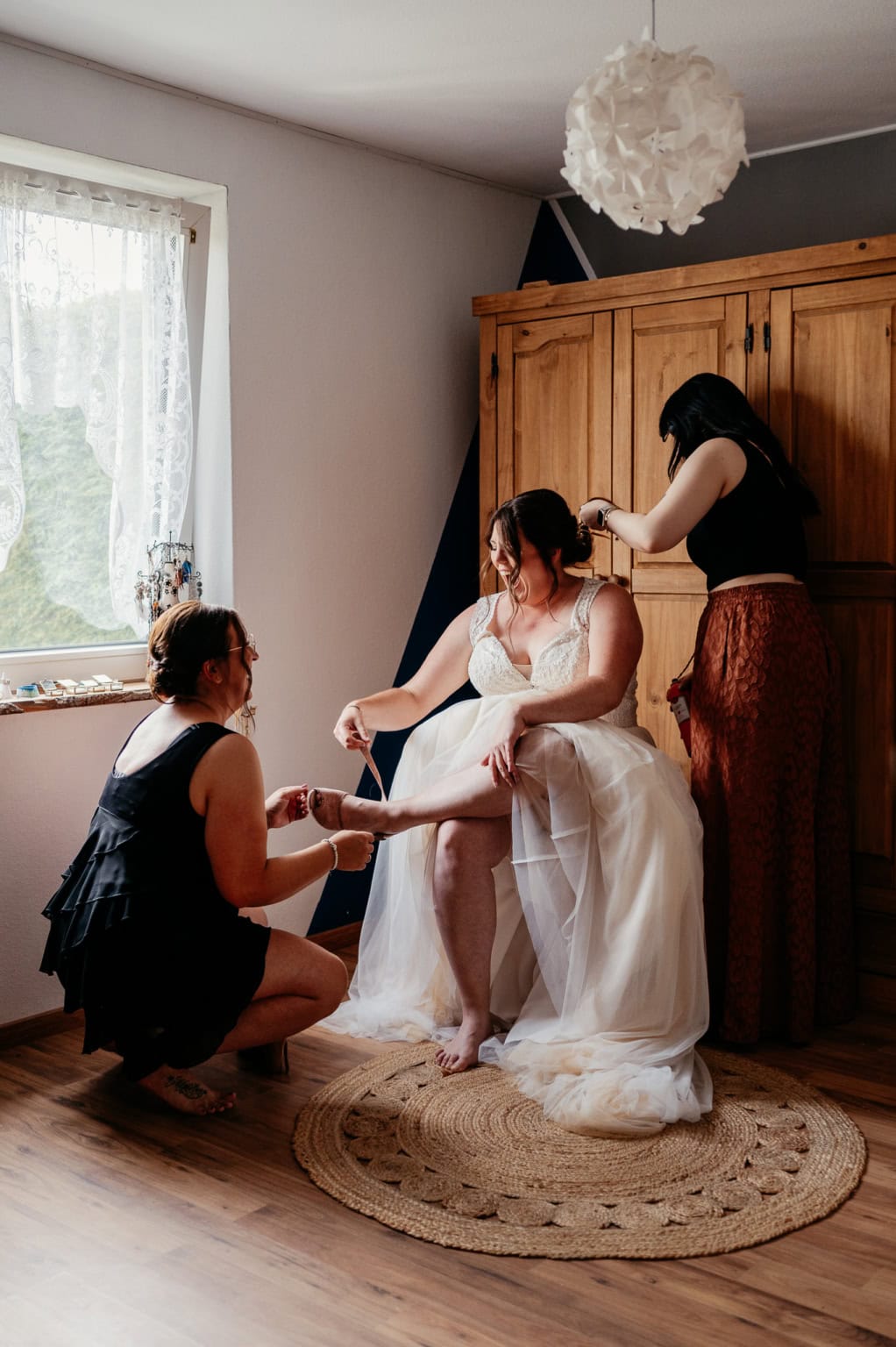 Braut wird von Freundinnen vor der Hochzeit fertig gemacht.