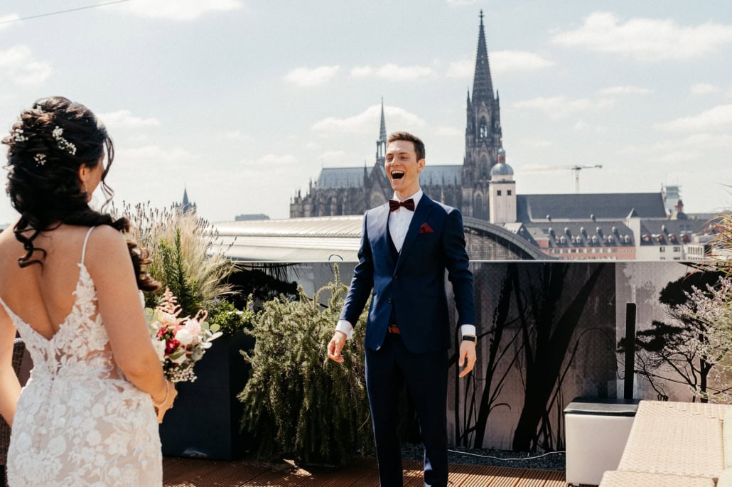 Hochzeitspaar auf der Dachterrasse mit Blick auf den Dom und die Stadt im Hintergrund.