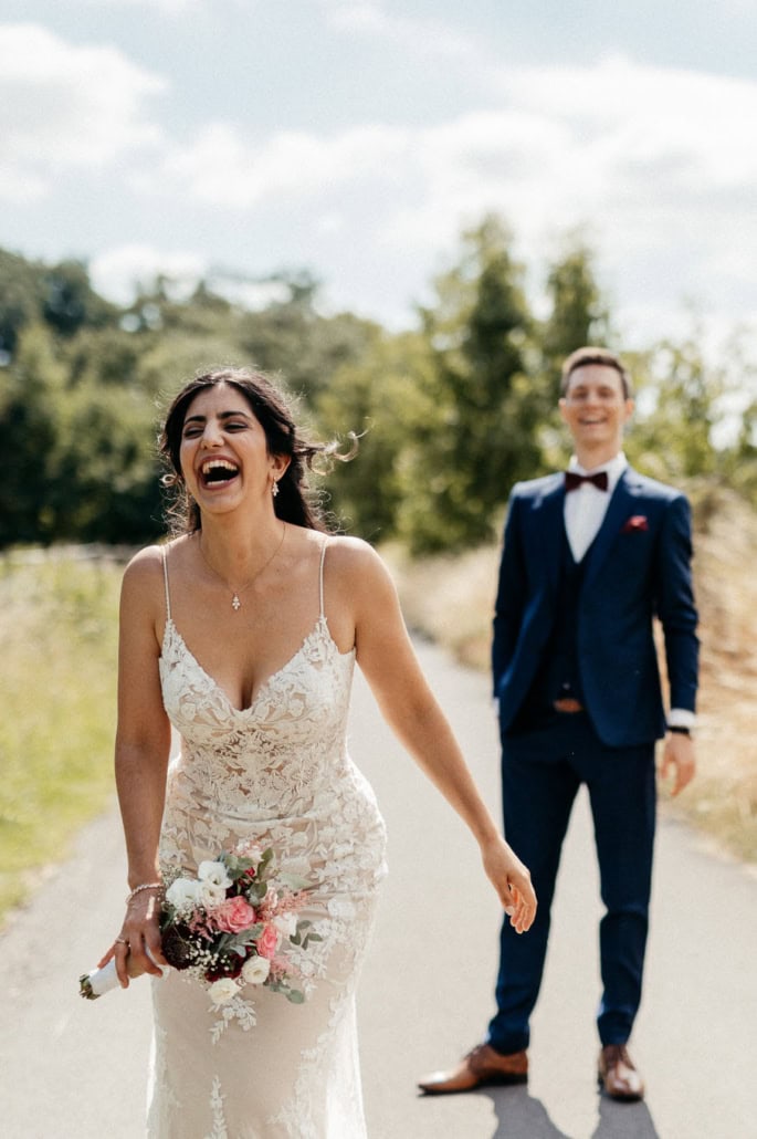 Hochzeitspaar beim Spaziergang im Grünen, authentische Hochzeitsmomente festgehalten.