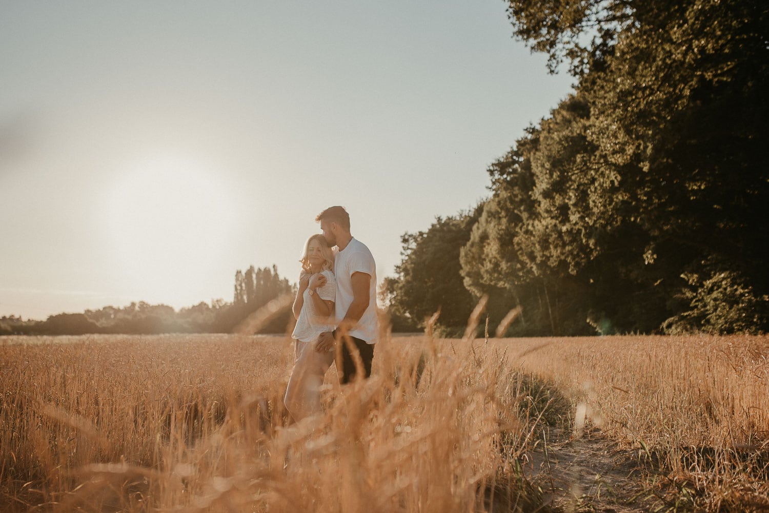 Familienfoto eines Mannes und eines Kindes beim Spaziergang im goldenen Sonnenlicht.